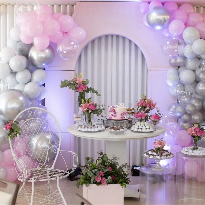 Pink and silver balloon arch behind a dessert table