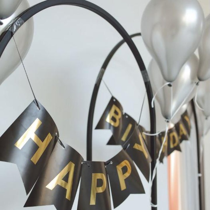 Black and gold happy birthday banner with silver balloons